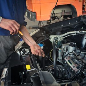 A mobile mechanic checks the oil level.