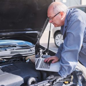 A mobile mechanic holds a pre-purchase vehicle inspection checklist.
